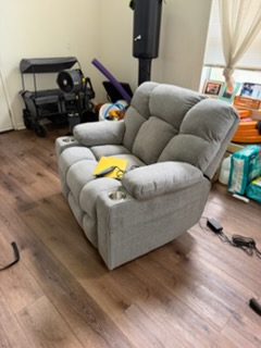 Gray upholstered reclining armchair in living room with hardwood flooring