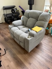Gray upholstered armchair with cushions in furnished room with wooden floor