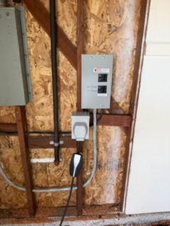 Electrical outlet and charging station mounted on wooden wall framing