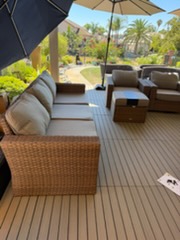 Outdoor patio with wicker furniture, umbrella, and resort landscape view