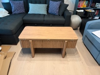 Modern wooden coffee table with vertical slat design in living room setting