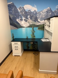 Home office with mountain lake mural, white desk, filing cabinet, and computer monitor