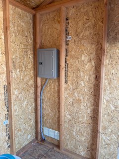 Interior of tiny home with OSB walls and electrical panel installation